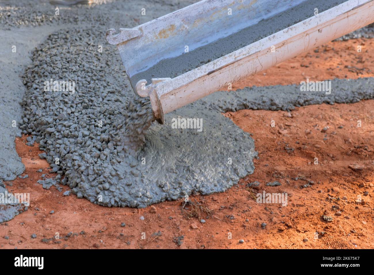 Während des Prozesses Pflasterung Auffahrt, Auftragnehmer aus Betonbauindustrie gießen nassen Beton Stockfoto