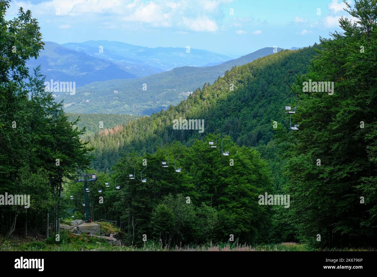 Sessellift über die Berge und wolkigen Himmel. Nationalpark Appennino Tosco-Emiliano. Lagdei, Emilia-Romagna Stockfoto