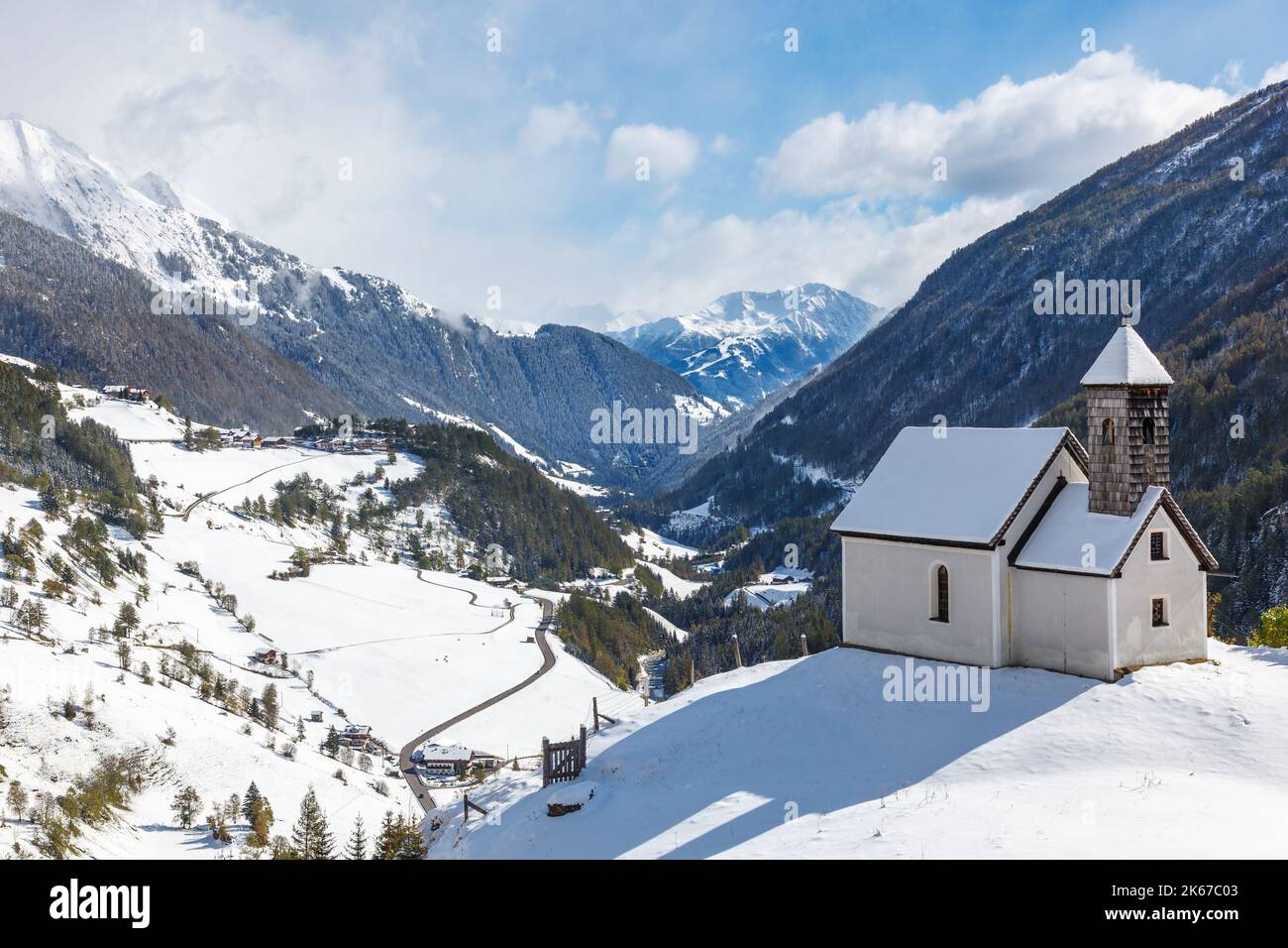 Kapelle auf einem Hügel in einem verschneiten Alptal Stockfoto