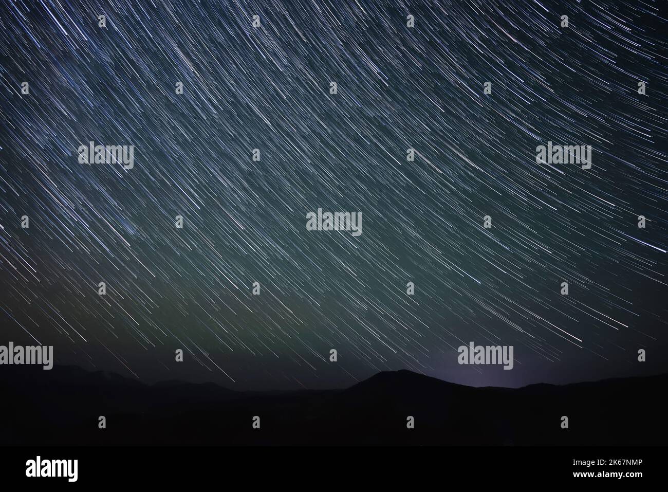Abstrakte Nachtlandschaft mit Sternenhimmel mit Spuren fallender Sterne in Form von Spuren über den Bergen. Altai, Russland Stockfoto