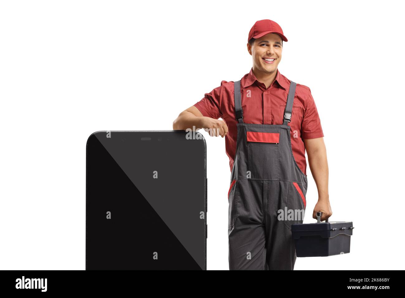 Reparaturman lehnt sich auf ein großes Smartphone und hält einen Werkzeugkasten isoliert auf weißem Hintergrund Stockfoto