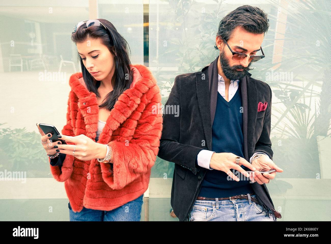 Hipster-Paar im traurigen Moment ignorieren einander mit Mobiltelefonen - Konzept der Apathie Traurigkeit süchtig nach neuen Technologien - Freund und Freundin Stockfoto