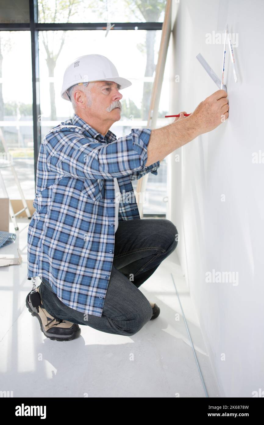 Senior Maurer mit einem Lineal Stockfoto