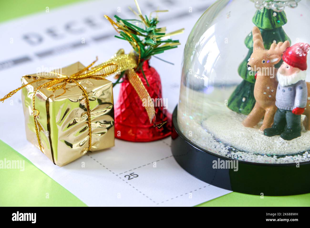Weihnachten Schneekugel, Geschenk und Glocke 25. Dezember Weihnachtstag im Kalender, Countdown zum großen Tag, festliche Stimmung Stockfoto