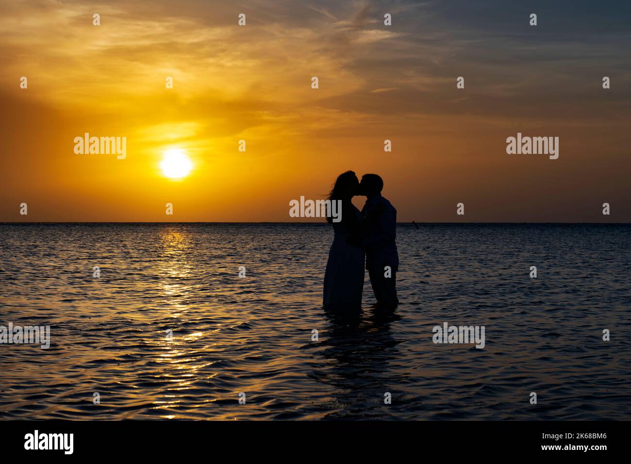 Junges, liebevolles Paar bei Sonnenuntergang in der Karibik. Stockfoto