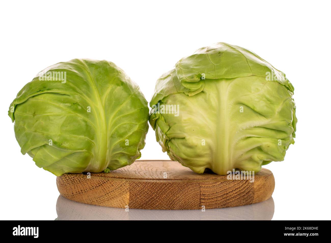 Zwei frische weiße Kohlköpfe auf einem Holztablett, Makro, isoliert auf weißem Hintergrund. Stockfoto