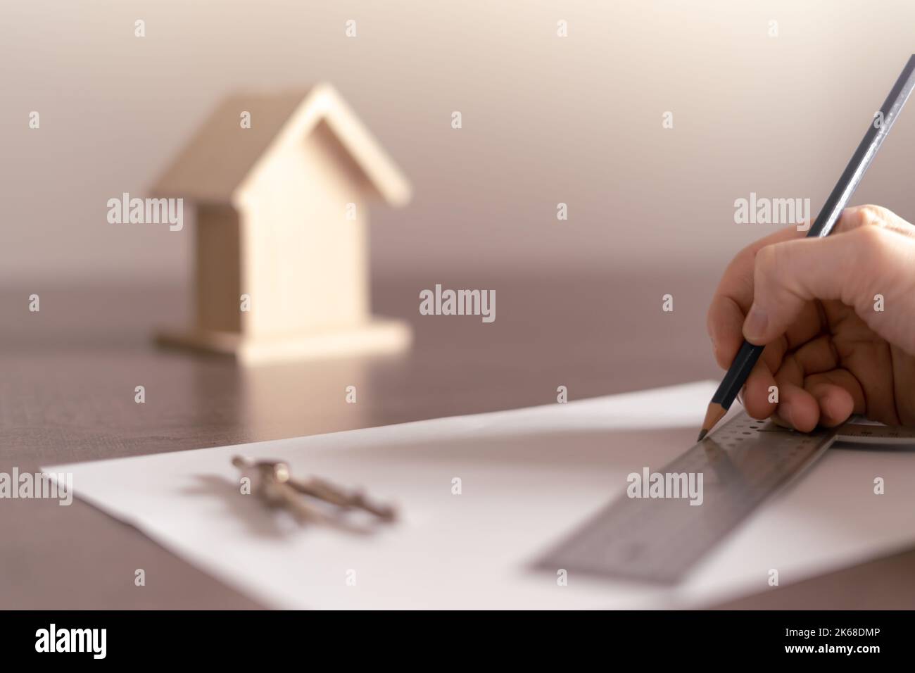 Hand des Architekten zeichnet die Skizze für das Bauprojekt eines Hauses für einen Bauherrn. Stockfoto