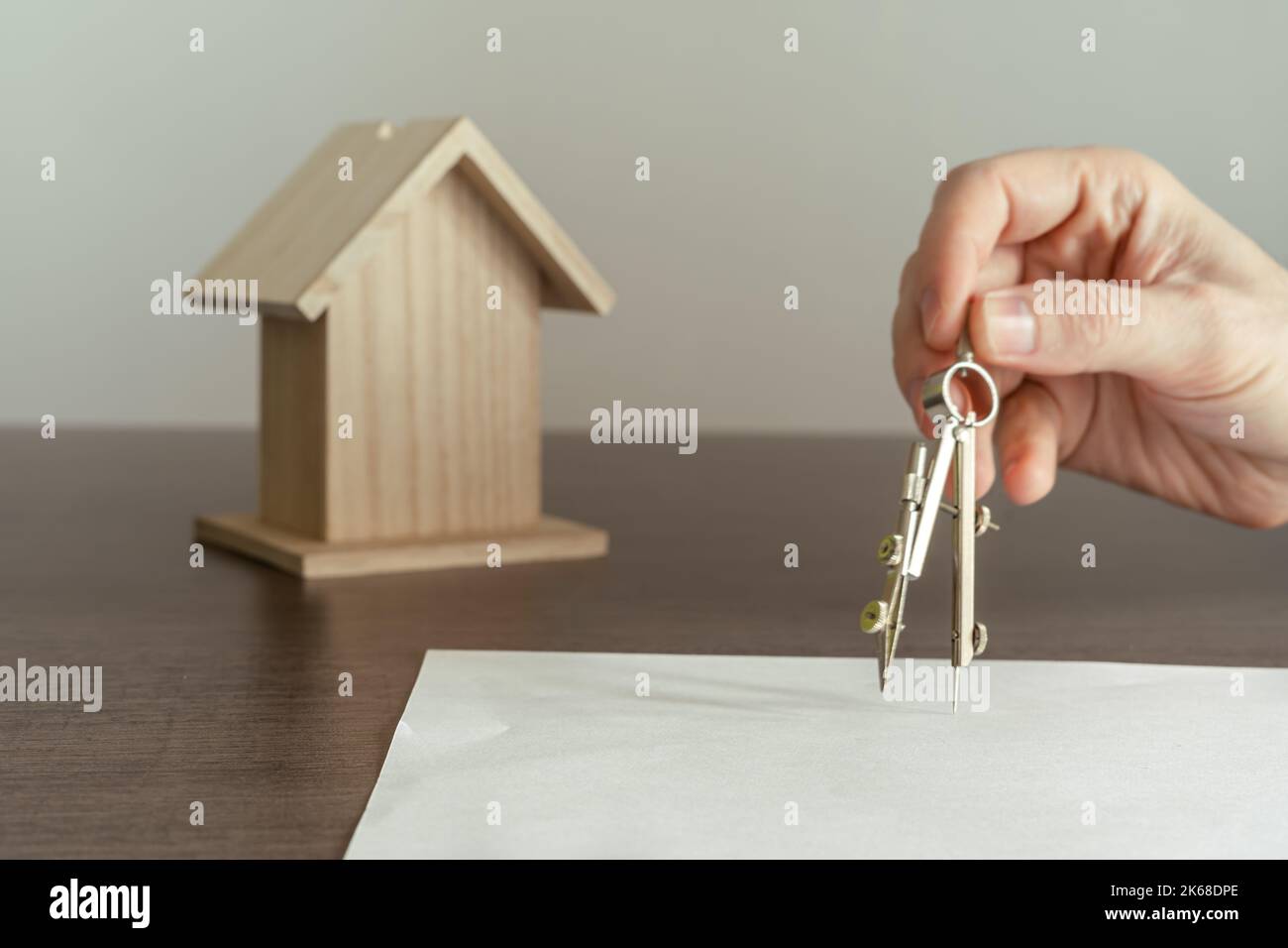 Architekt zeichnet mit dem Kompass auf ein weißes Papier die Pläne für ein neues Zuhause für eine Familie. Stockfoto