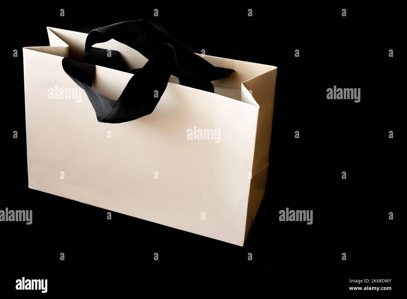 Einkaufstasche aus Pappe auf schwarzem Hintergrund mit Platz zum Schreiben. Black friday Verkaufskonzept. Stockfoto