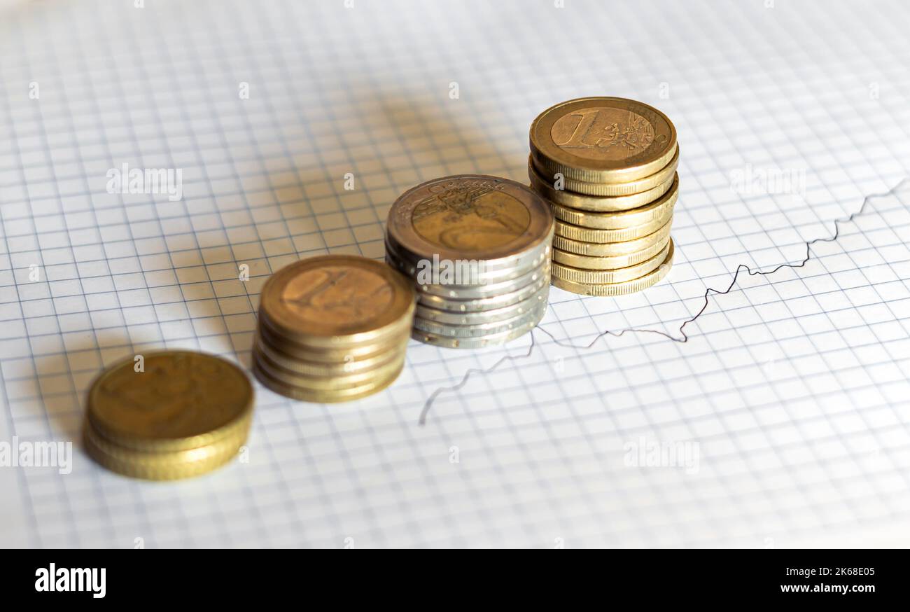 Grafische Darstellung der steigenden Inflation mit immer mehr gestapelten Münzen. Stockfoto