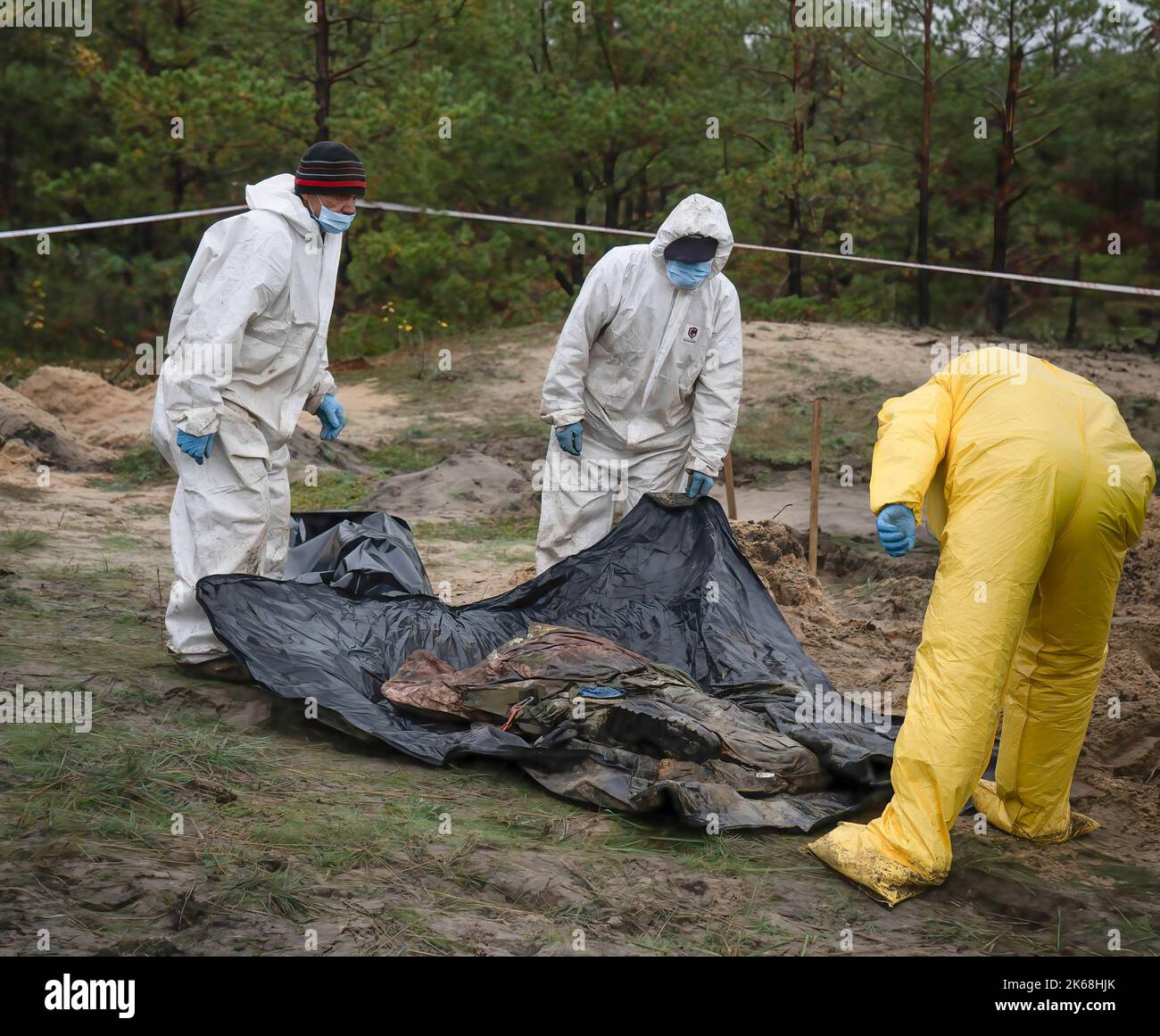 (ANMERKUNG DES HERAUSGEBERS: Bilder zeigen den Tod) Ermittler, die Schutzkleidung tragen, werden gesehen, wie sie die Leichen ukrainischer Soldaten von einer Grabstätte in Lyman exhumieren. Mindestens 32 ukrainische Soldatenleichen wurden aus einem Massengrab in Lyman, einer Stadt im Donezker Gebiet, die unter russischer Besatzung stand, exhumiert. Die Behörden sagten, dass sie zusammen begraben wurden und erste Untersuchungen zeigten, dass einige Leichen mit verbundenen Augen und an den Händen gebunden waren, was Anzeichen von Folter und Hinrichtung nahelegt. Weitere 22 Zivilisten, darunter auch Kinder, wurden von einer anderen Begräbnisstätte in der Nähe exhumiert. Beide Standorte befinden sich am Rand eines c Stockfoto