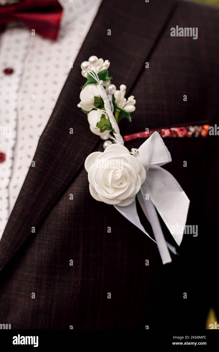 Eine weiße Boutonniere Blume auf der Jacke des Bräutigams. Hochzeitstag Stockfoto