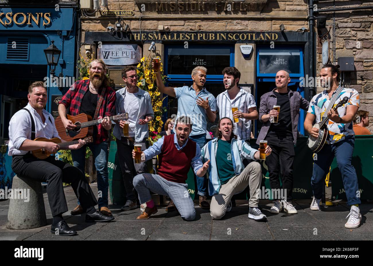 Chor der man-Gruppe singt, spielt Musik und trinkt Bier in der kleinsten Kneipe in Schottland, Grassmarket, Edinburgh, Schottland, Großbritannien Stockfoto