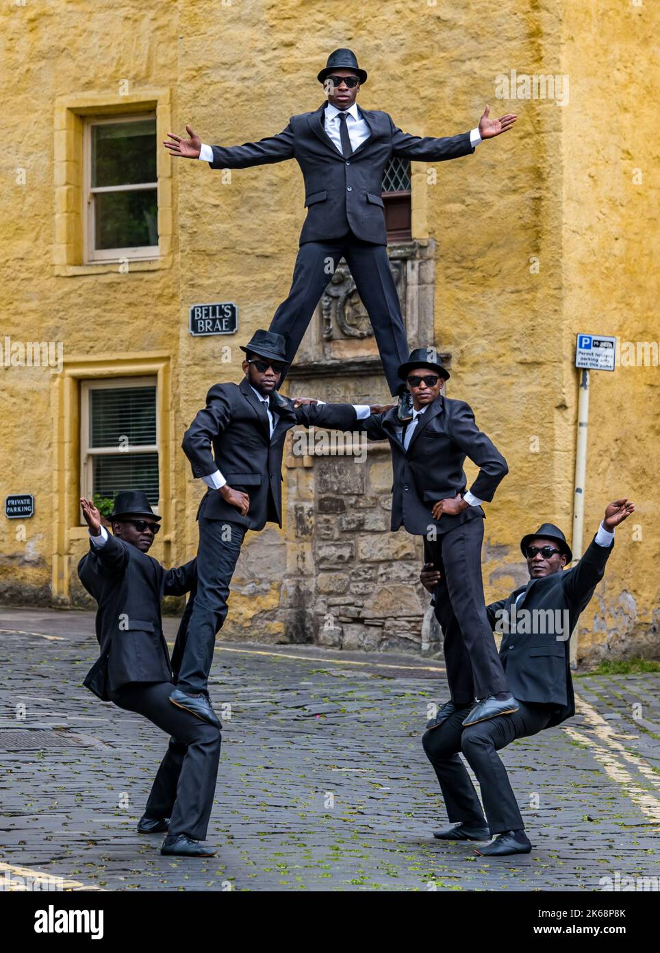 Die akrobatische Gruppe der Black Blues Brothers treten im Dean Village auf, um eine menschliche Pyramide zu erschaffen, Edinburgh, Schottland, Großbritannien Stockfoto