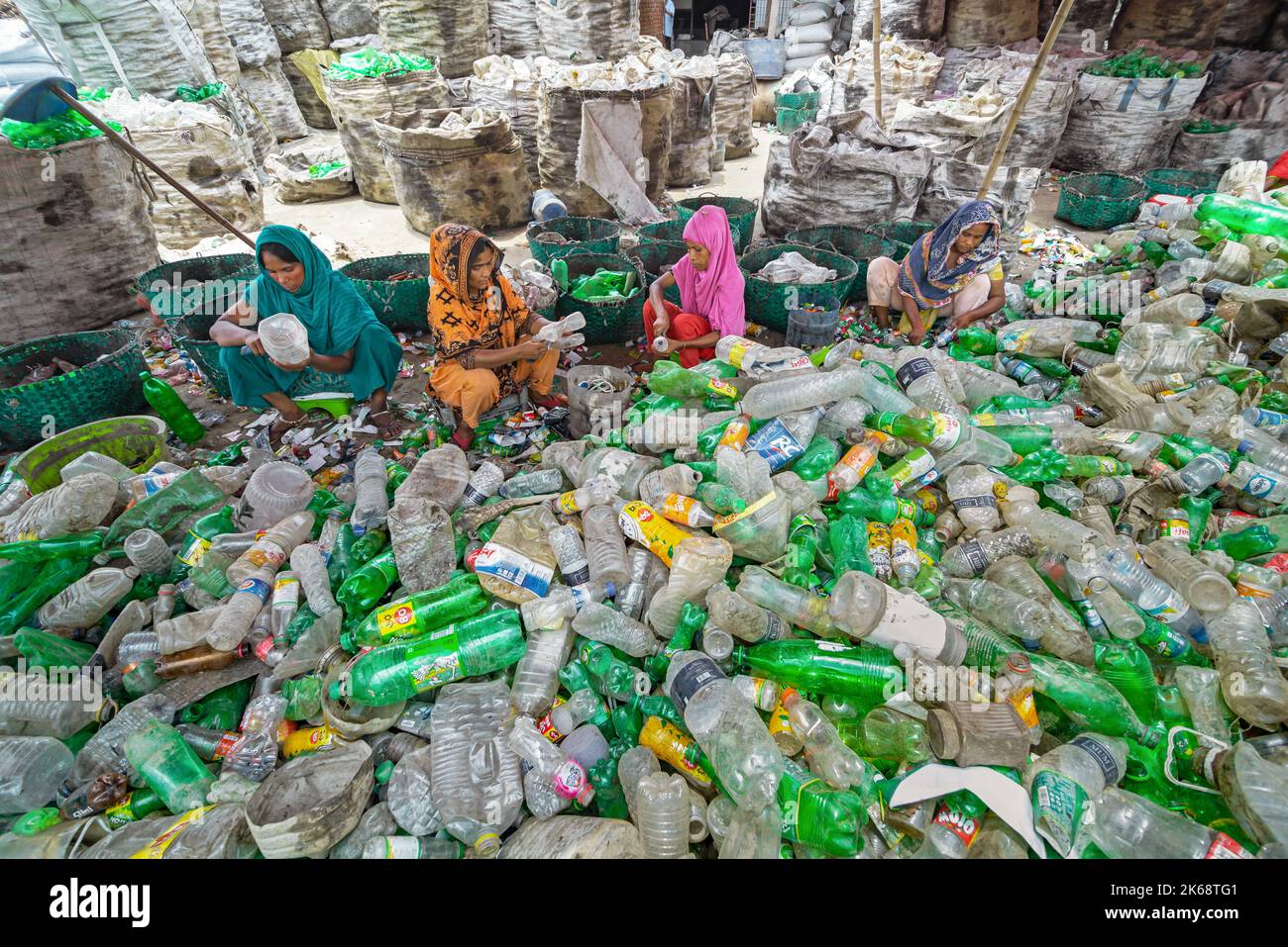 Arbeiter sortieren gebrauchte Plastikflaschen in einer Recyclingfabrik. Das Recycling von Kunststoffen ist der beste Weg, um unsere Umwelt sauber und sicher zu machen. Stockfoto
