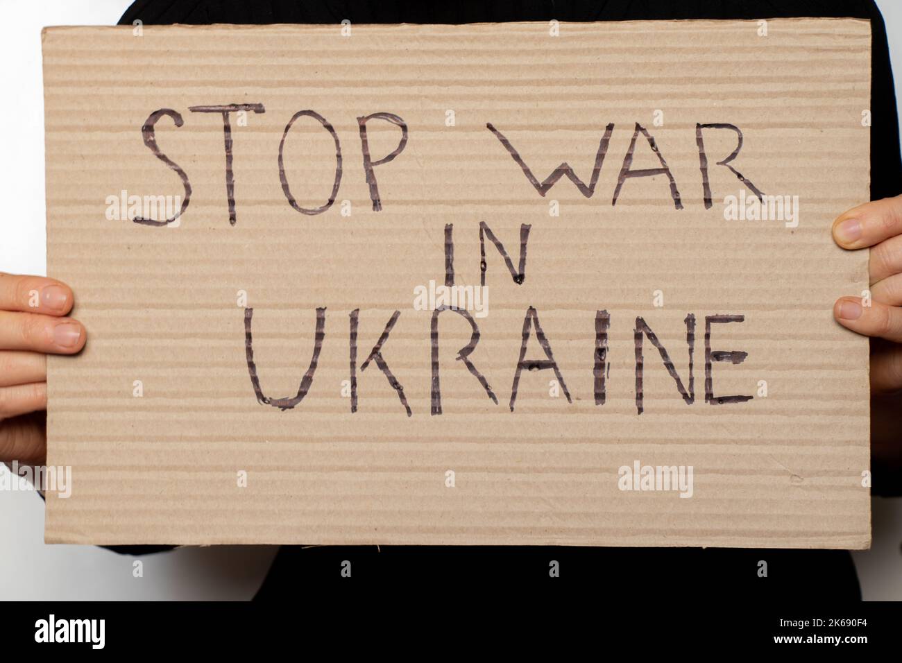 Stoppen Sie den Krieg in der Ukraine geschrieben auf einem Zeichen, dass eine Frau in ihren Händen hält von ihrem Haus in der Dnjepr, Protestaktion, Kriegsrecht in der Ukraine Stockfoto