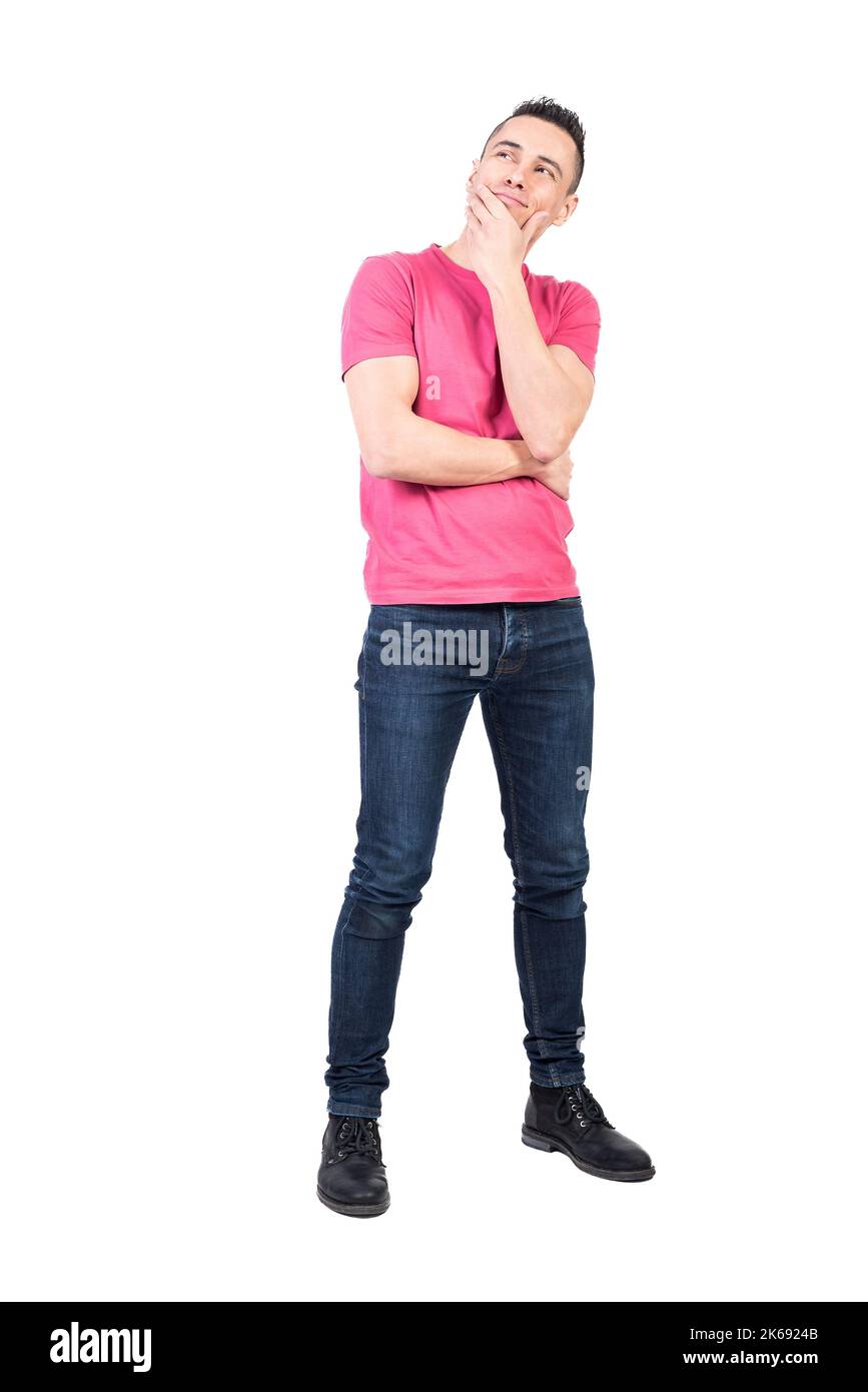 Positiver Mann im lässigen Outfit, der Kinn berührt und denkt Stockfoto