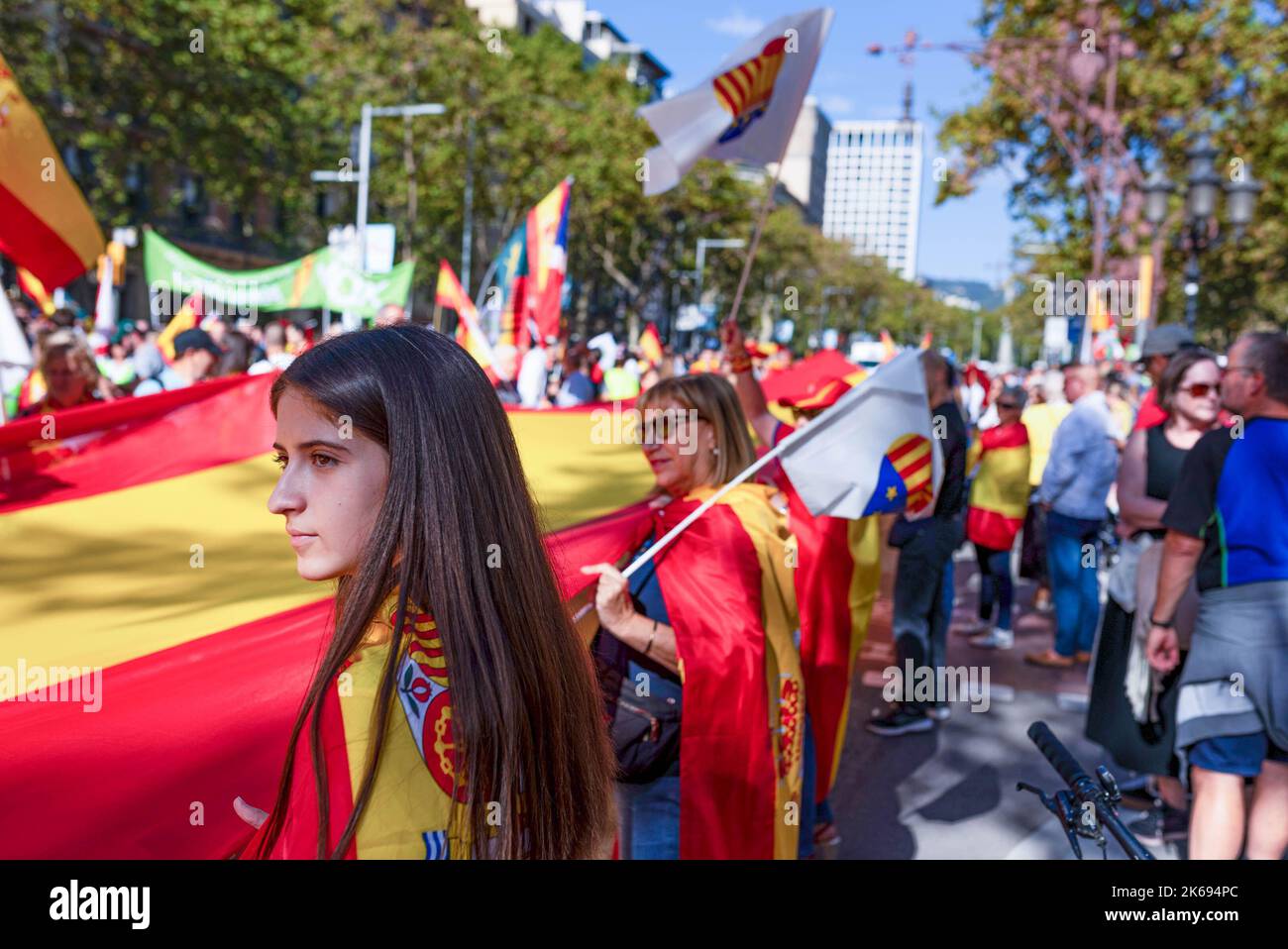 Barcelona, Spanien. 12. Oktober 2022. Während der Parade zum Hispanic Day wird eine junge Frau aus der Nähe gesehen, während sie eine große Flagge Spaniens hält. Der Hispanic Day, auf Spanisch bekannt als Dia de España, feiert den Jahrestag des Datums, an dem Christoph Kolumbus in Amerika ankam, wurde aber vor kurzem wegen seiner Feier der Kolonisierung auf den Prüfstand gestellt. (Foto von Davide Bonaldo/SOPA Images/Sipa USA) Quelle: SIPA USA/Alamy Live News Stockfoto