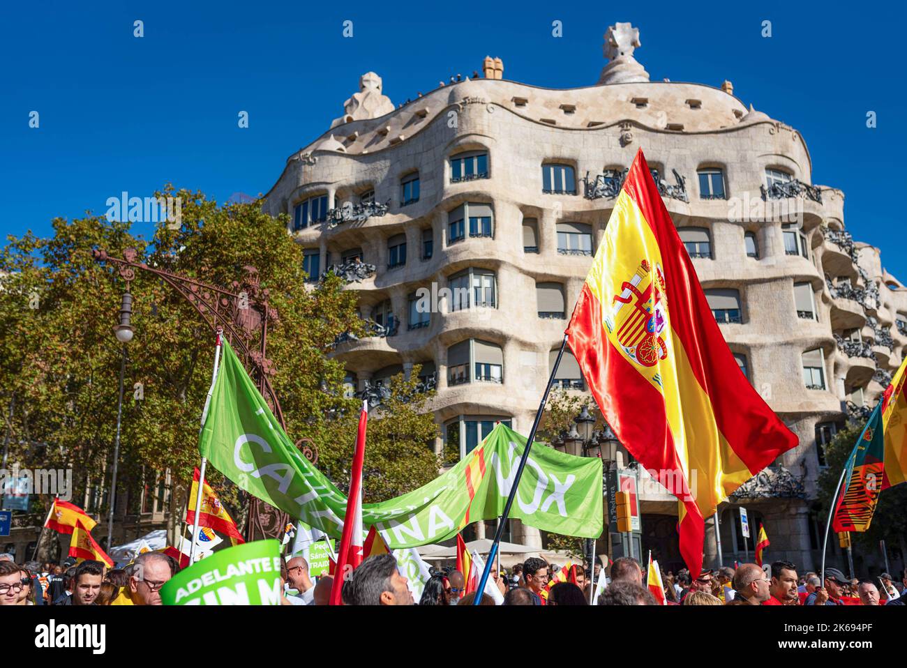 Barcelona, Spanien. 12. Oktober 2022. Während der Parade zum Hispanic Day winken vor dem Wahrzeichen von La Pedrera spanische Flaggen. Der Hispanic Day, auf Spanisch bekannt als Dia de España, feiert den Jahrestag des Datums, an dem Christoph Kolumbus in Amerika ankam, wurde aber vor kurzem wegen seiner Feier der Kolonisierung auf den Prüfstand gestellt. (Foto von Davide Bonaldo/SOPA Images/Sipa USA) Quelle: SIPA USA/Alamy Live News Stockfoto