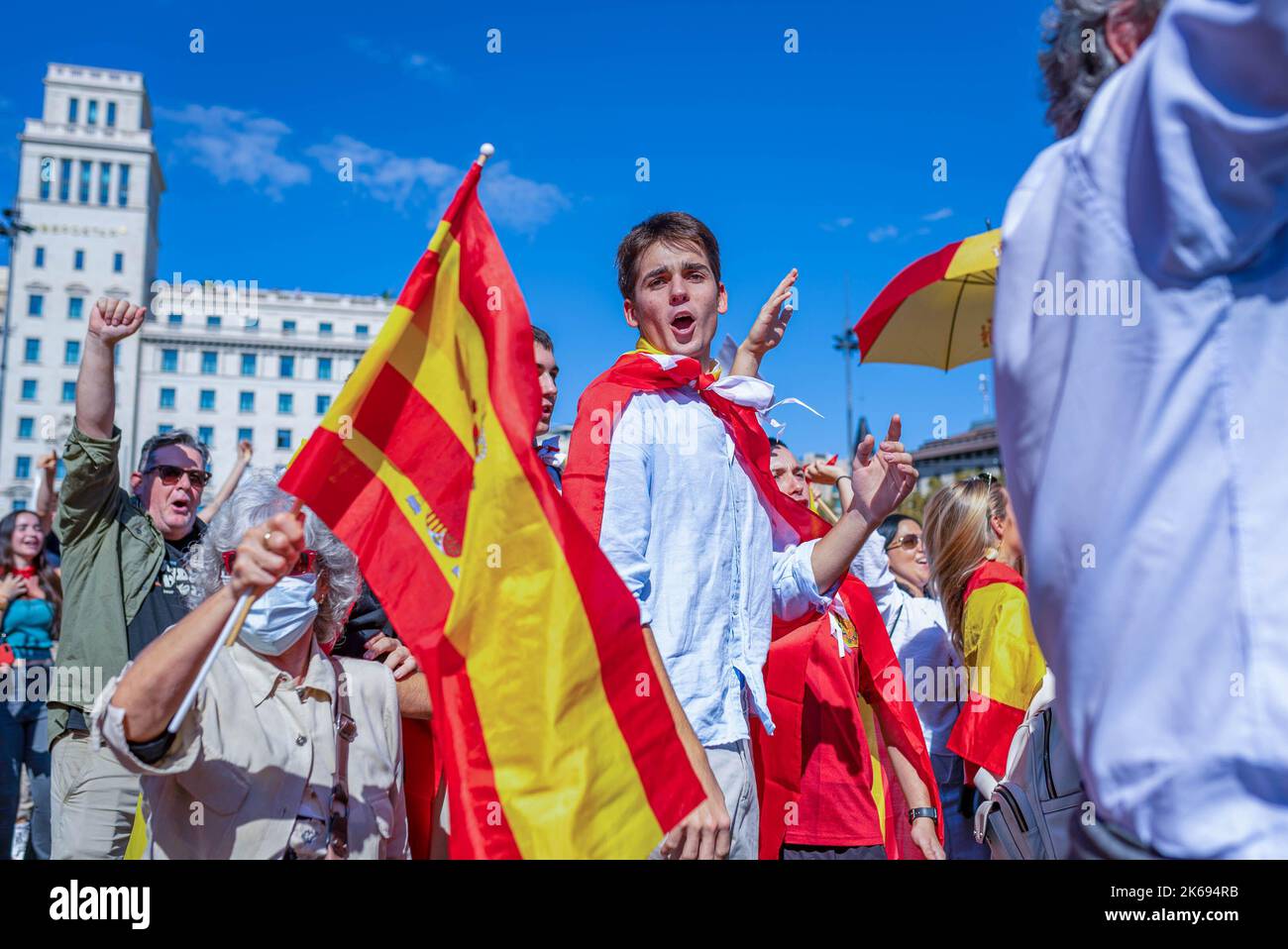 Barcelona, Spanien. 12. Oktober 2022. Während der Parade zum Hispanic Day wird ein junger Mann in der Menge zwischen spanischen Flaggen hüpfen und singen sehen. Der Hispanic Day, auf Spanisch bekannt als Dia de España, feiert den Jahrestag des Datums, an dem Christoph Kolumbus in Amerika ankam, wurde aber vor kurzem wegen seiner Feier der Kolonisierung auf den Prüfstand gestellt. (Foto von Davide Bonaldo/SOPA Images/Sipa USA) Quelle: SIPA USA/Alamy Live News Stockfoto