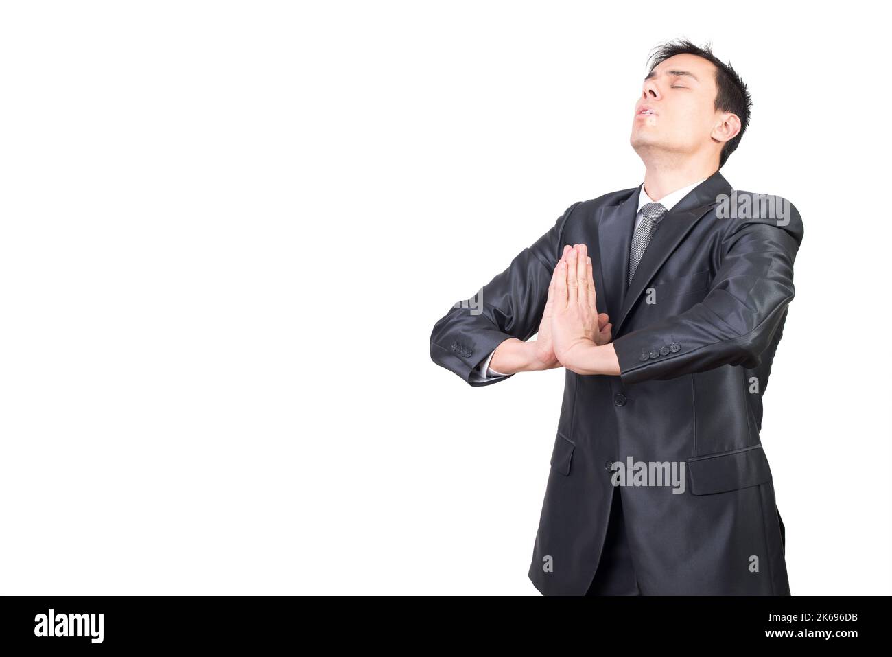 Mann in elegantem Anzug meditiert im Studio Stockfoto