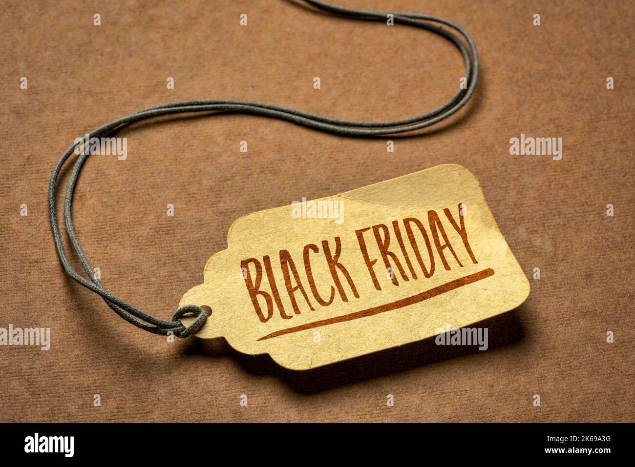 Black Friday sign - ein Papierpreisschild mit einer Garnierung gegen Texturpapier, Herbstferien und Einkaufskonzept Stockfoto