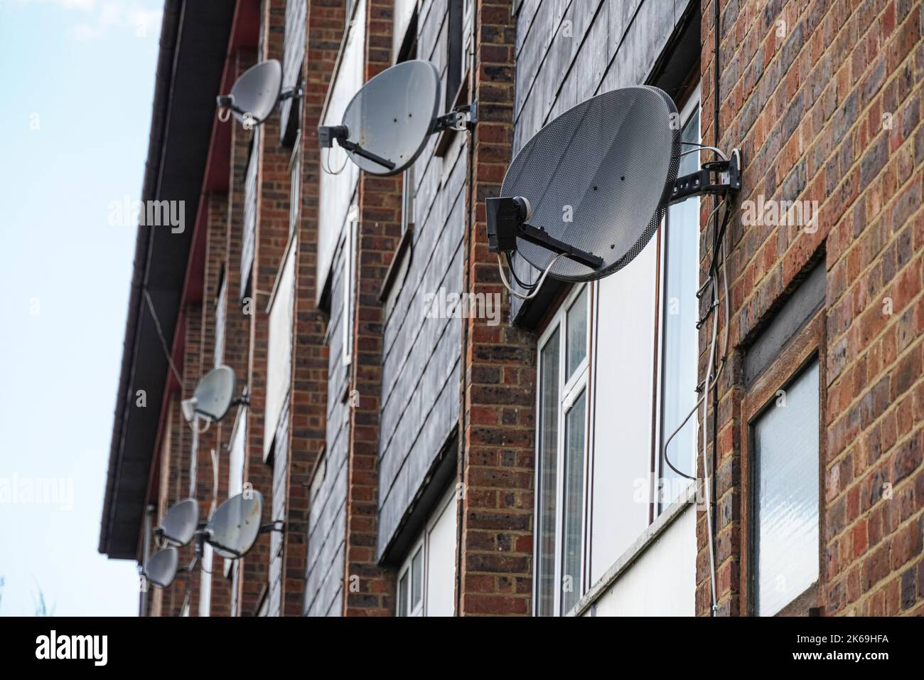 Satellitenschüsseln an einer Wand eines Wohnblocks, London, England, Großbritannien Stockfoto
