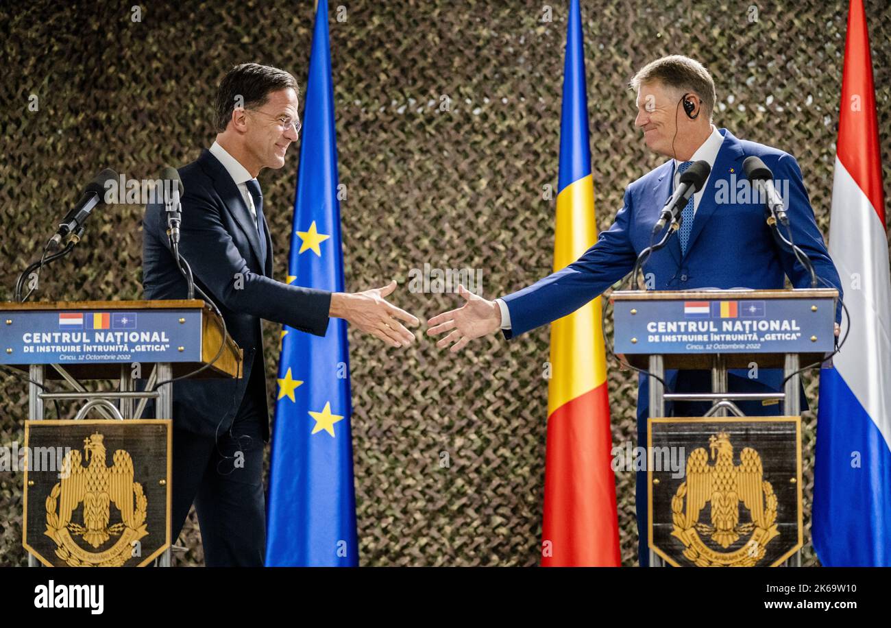 2022-10-12 16:49:58 CINCU - Premierminister Mark Rutte, Präsident Klaus Johannis und Premierminister Nicolae Ciuca, während einer Pressekonferenz, an einer Militärbasis, wo niederländische Truppen stationiert sind, während eines Besuchs in Rumänien. Der Premierminister diskutiert unter anderem die militärische Zusammenarbeit zwischen den Niederlanden und Rumänien. ANP BART MAAT niederlande Out - belgien Out Stockfoto