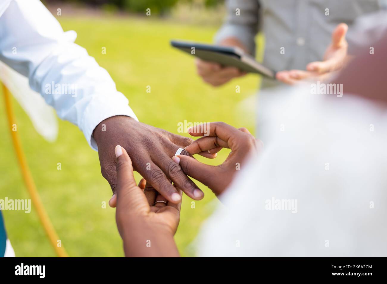 Nahaufnahme eines afroamerikanischen Paares, das während der Hochzeit den Ring legt Stockfoto