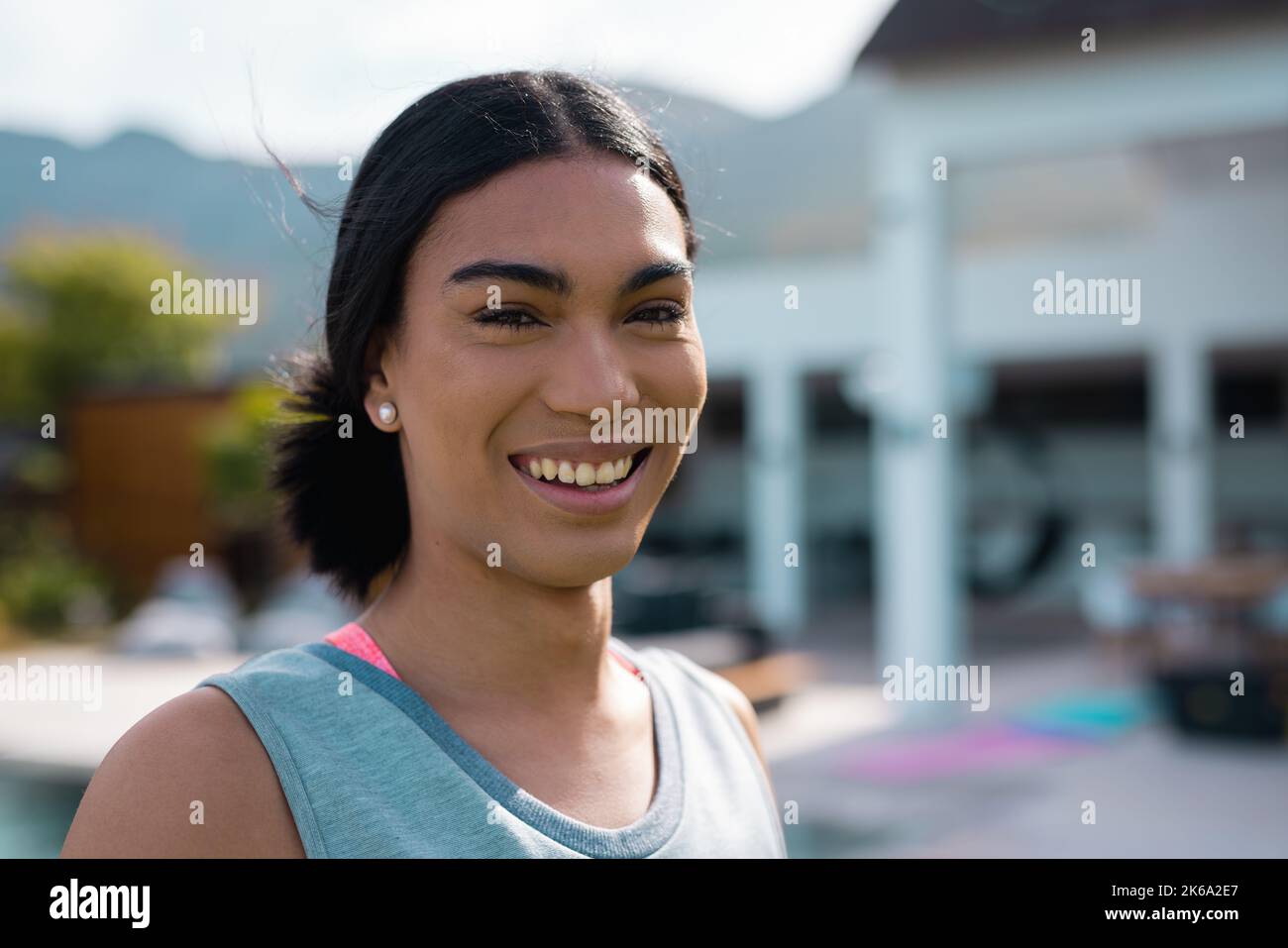 Porträt einer glücklichen, birassischen Frau, die im Garten lächelt Stockfoto