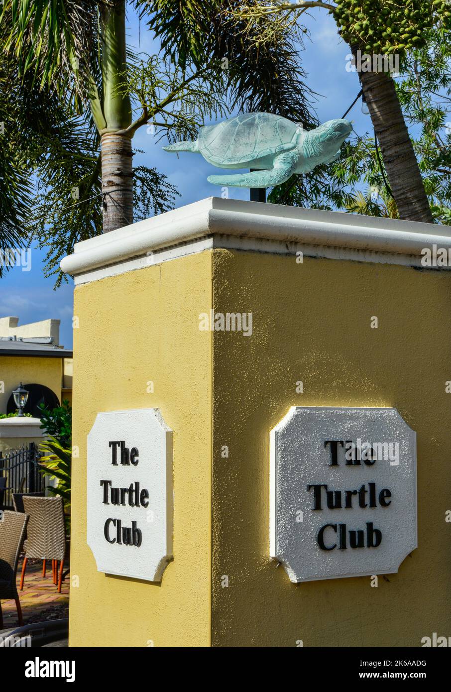 Der Eingang des feinen Restaurants Turtle Club im Innenhof mit Säule und Namensschild mit Schildkrötenskulptur und Palmen in Punta Gorda, FL Stockfoto