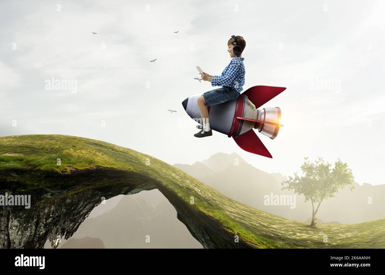 Kind trägt Kopfhörer auf einer Rakete Stockfoto