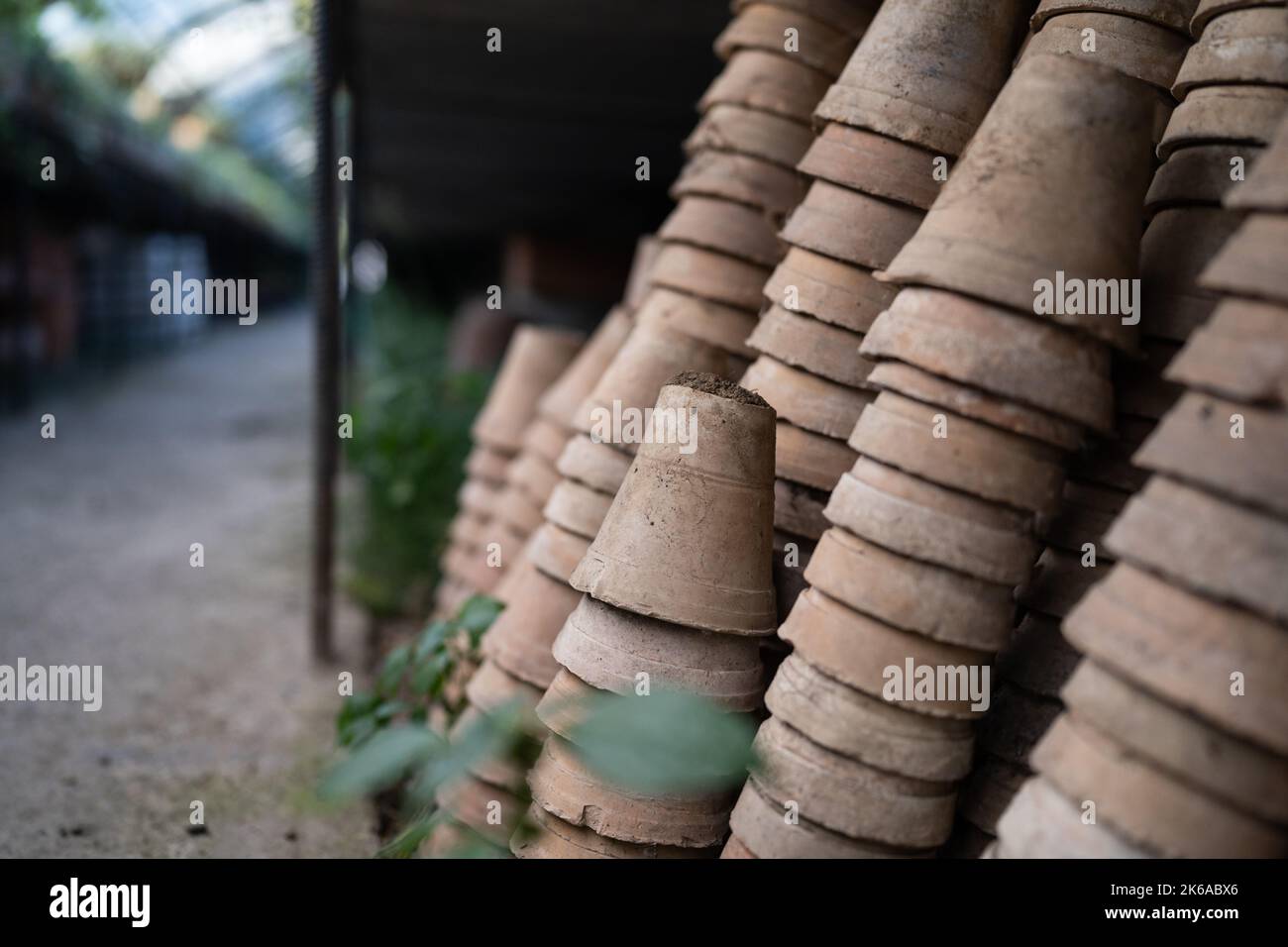 Nahaufnahme von Stapeln alter verwitterter Terrakotta-Blumentöpfe im Gartenschuppen Stockfoto