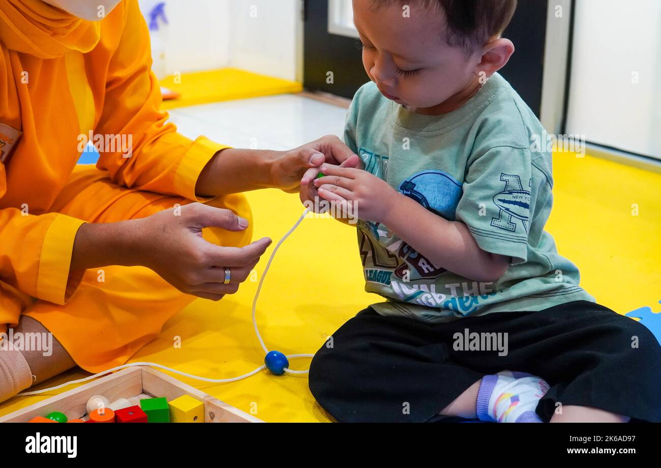 Jakarta, Indonesien 12. 2022 : Ergotherapie bei Kindern. Männliche Kinder machen mit seinem Therapeuten spielerische Übungen. Stockfoto