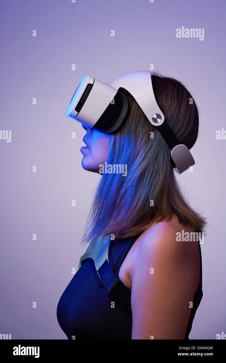 Frau verwendet ein Virtual-Reality-Headset. Konzept der virtuellen, erweiterten und erweiterten Realität, Metaverse, Unterhaltung und Kommunikation. Stockfoto