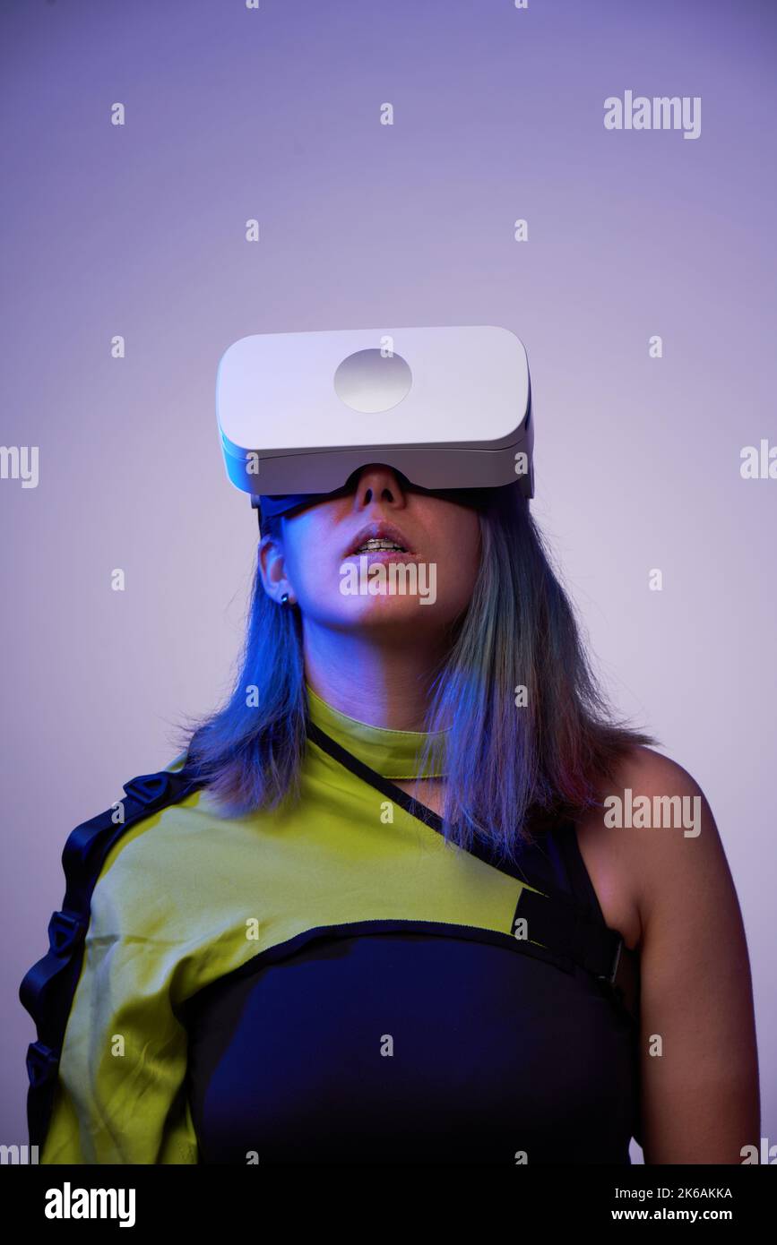 Frau verwendet ein Virtual-Reality-Headset. Konzept der virtuellen, erweiterten und erweiterten Realität, Metaverse, Unterhaltung und Kommunikation. Stockfoto