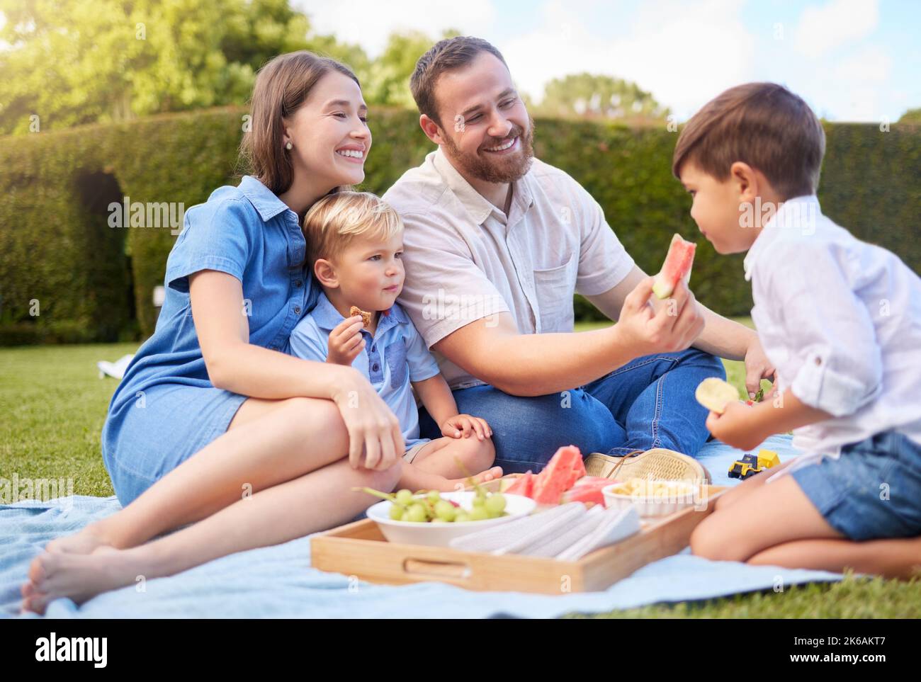 Alles, was Sie brauchen, ist Familie und Essen. Eine junge Familie, die ein Picknick im Park macht. Stockfoto