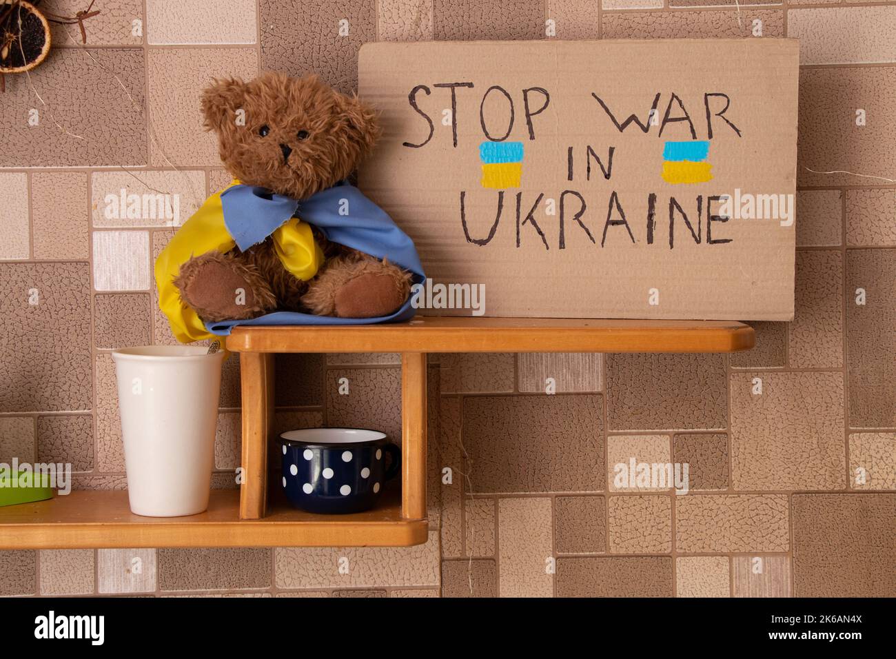 Stoppen Sie den Krieg in der Ukraine je geschrieben auf einem Schild, das auf Regal in der Ukraine in der Nähe eines Teddybären steht. Frieden in der Ukraine. Protest Stockfoto