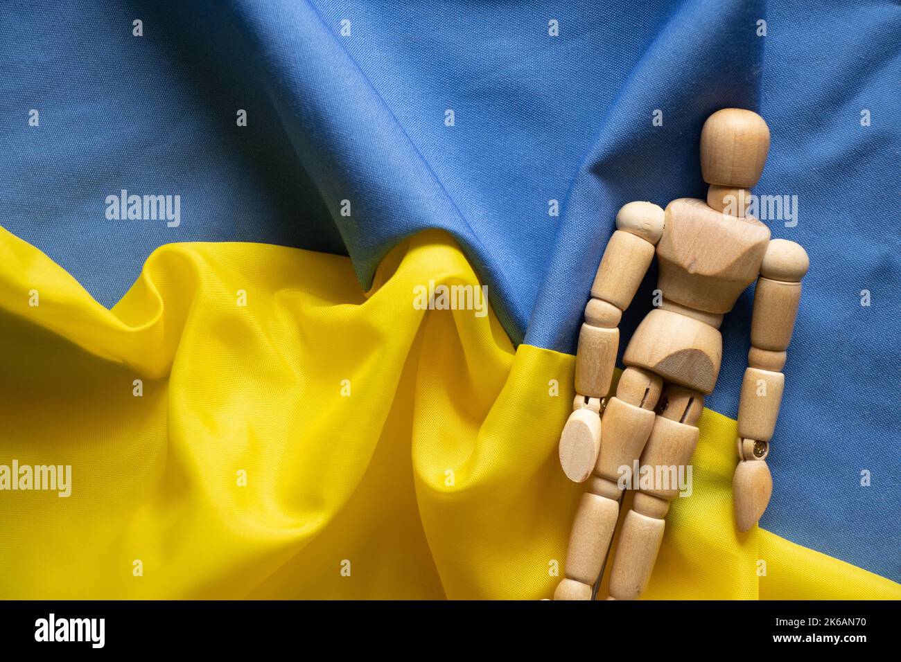 Gelbe und blaue Nationalflagge der Ukraine als Hintergrund und Holzmann, stoppen Krieg und Frieden in der Ukraine 2022 Stockfoto