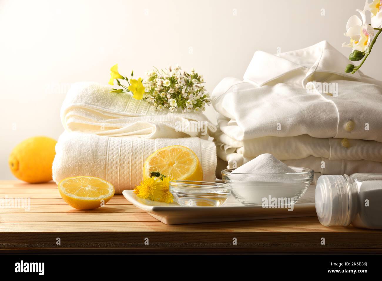 Hausmittel zum nachhaltigen und natürlichen Waschen von Kleidung mit Zitrone, Bikarbonat und Essig mit Kleidung auf einem Holztisch. Draufsicht. Horizont Stockfoto