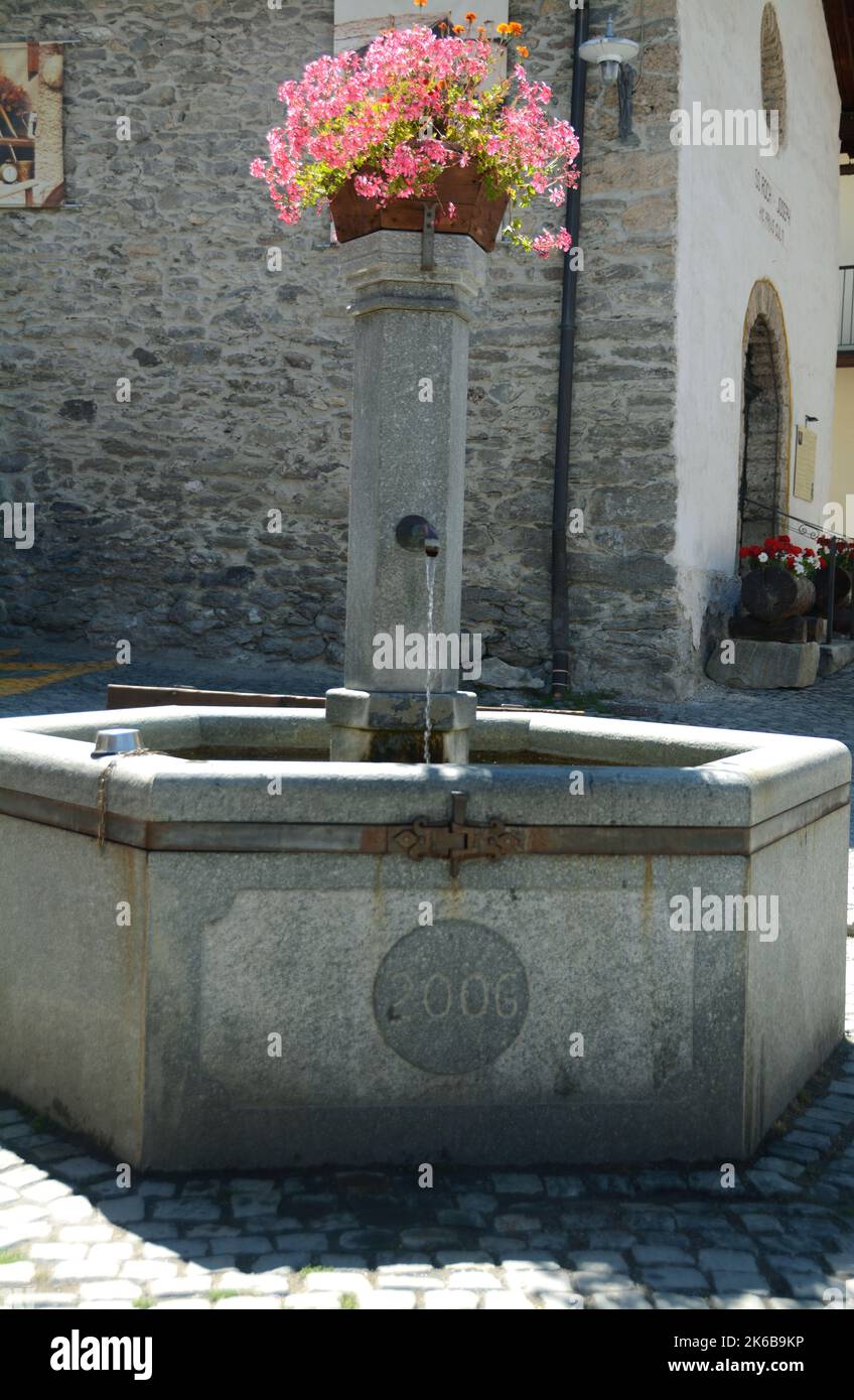 Alte Steinbrunnen im mittelalterlichen Zentrum von Sauze d'Oulx im oberen Val di Susa Stockfoto