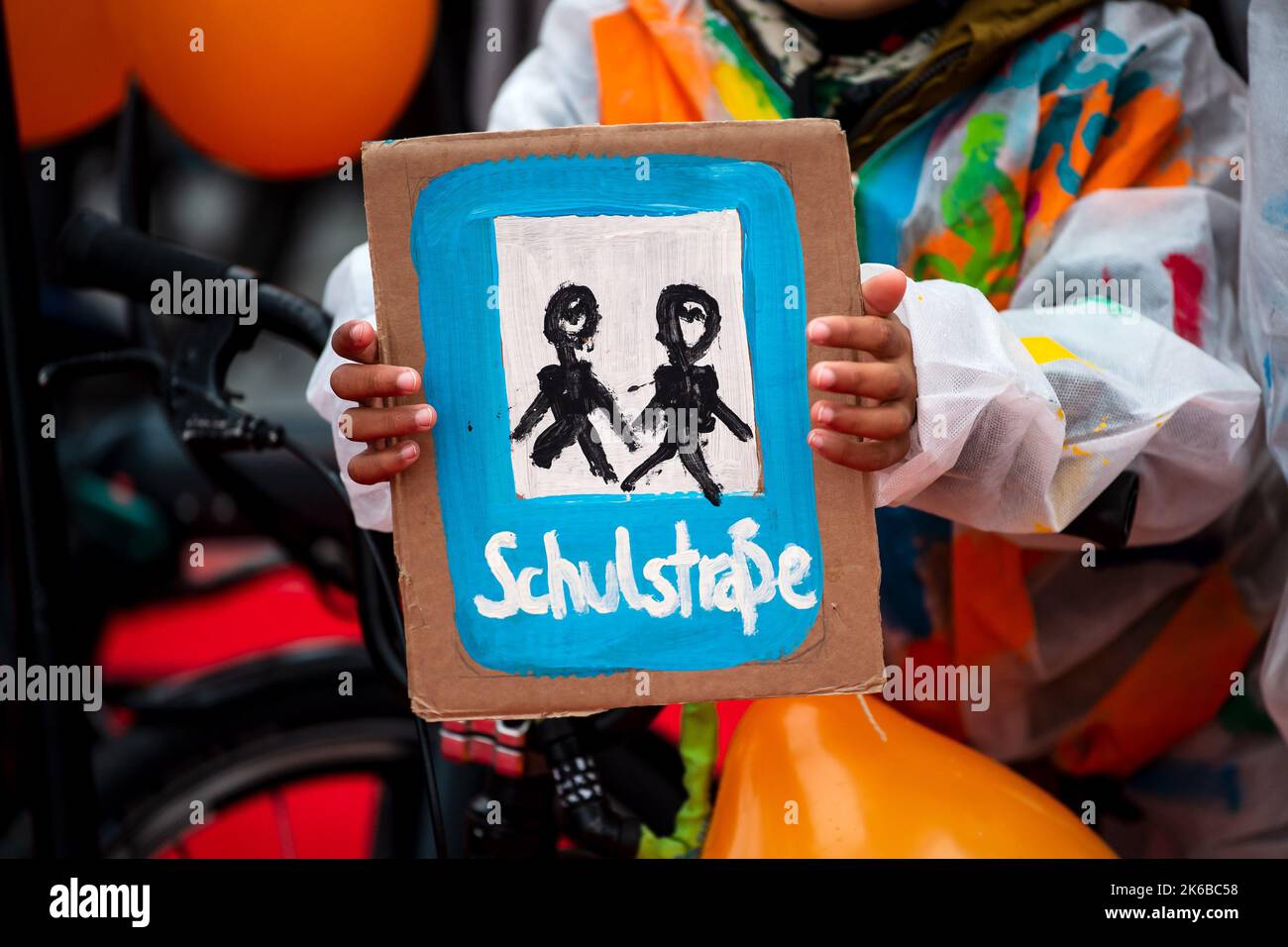 Bremerhaven, Deutschland. 13. Oktober 2022. Ein Kind hält ein selbst bemaltes Plakat mit der Aufschrift „Schulstraße“. Eine Allianz lokaler und nationaler Organisationen demonstriert vor dem Veranstaltungsort der Konferenz der Verkehrsminister. Zwei Petitionen fordern ein neues Straßenverkehrsgesetz und einen Nachfolger des 9-Euro-Tickets. Quelle: Sina Schuldt/dpa/Alamy Live News Stockfoto