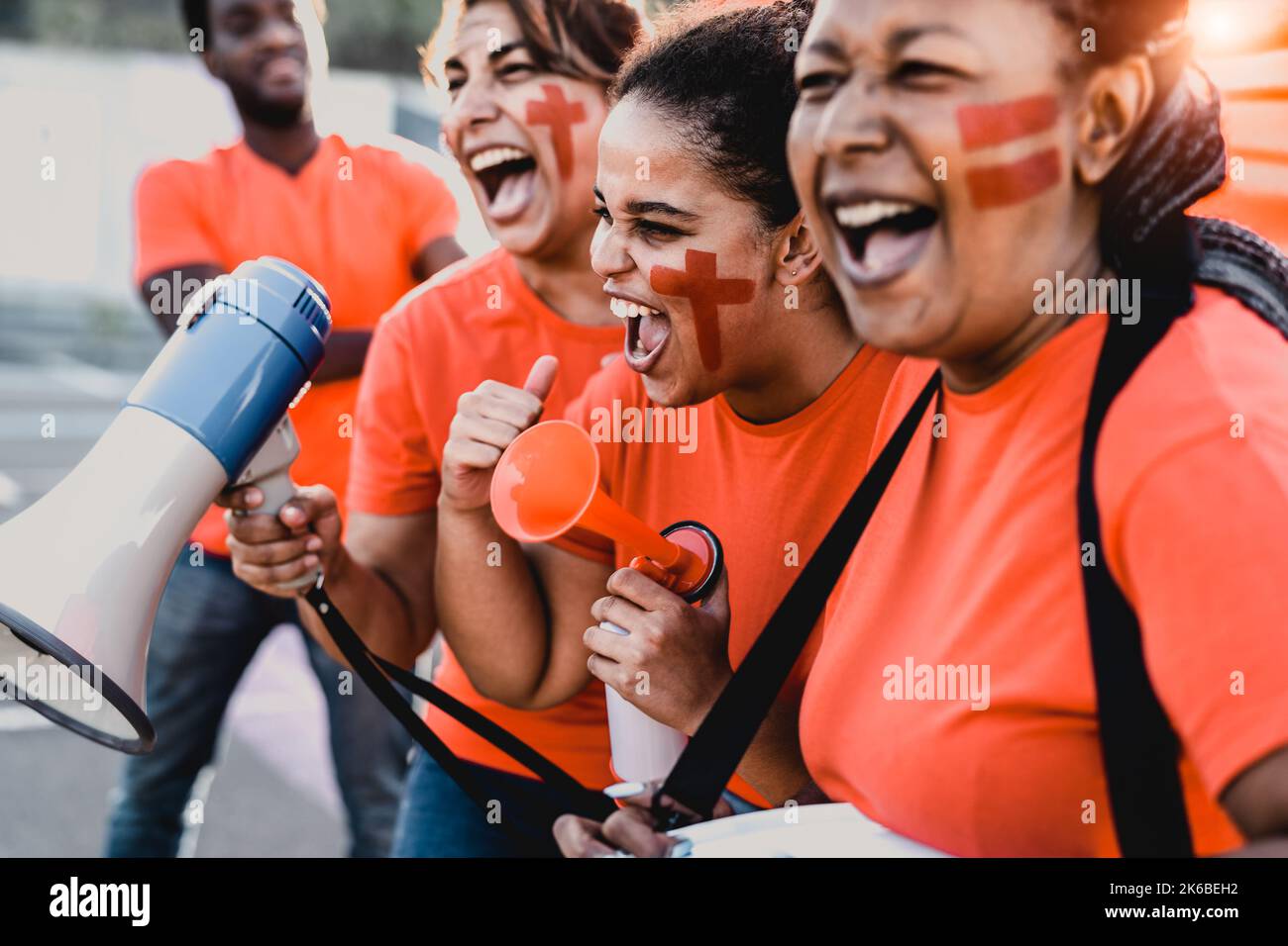 Frauen Fußballfans jubelten beim Fußballspiel im Stadion - Frauen mit gemaltem Gesicht und Megaphon ermutigen ihr Team Stockfoto