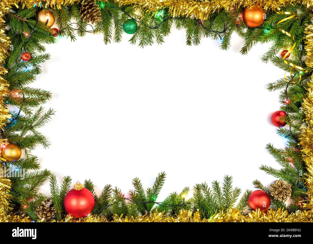 Weihnachtsrahmen aus Tannenzweigen, Kugeln, Kegeln und mehrfarbigen elektrischen Weihnachtslichtern auf weißem Hintergrund Stockfoto