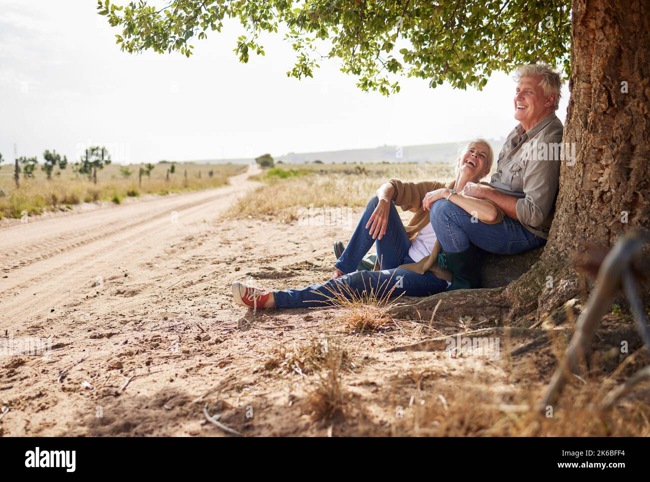 Dies ist das Leben, das wir wählen und lieben. Ein Seniorenpaar sitzt zusammen unter einem Baum. Stockfoto