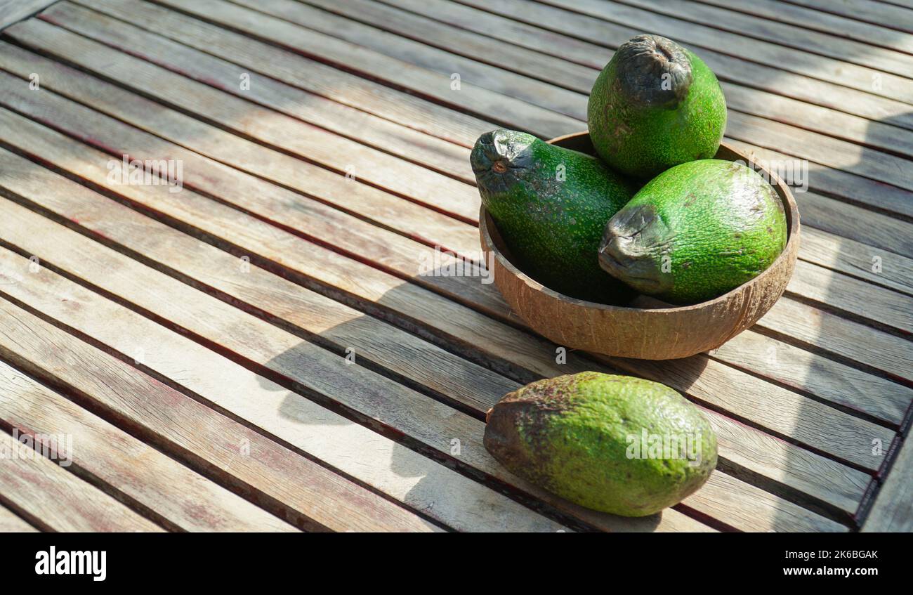 Gruppe reifer Avocados in Bambusschüssel auf Holzboden. Selektiver Fokus. Stockfoto