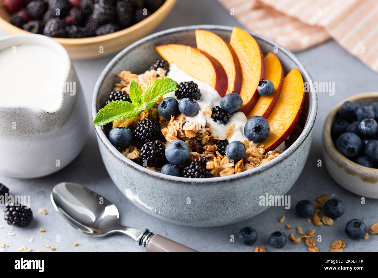 Müslischale und Joghurtschüssel mit Pfirsich und Beeren, Nahaufnahme. Gesundes Fitness-Menü Frühstück Stockfoto