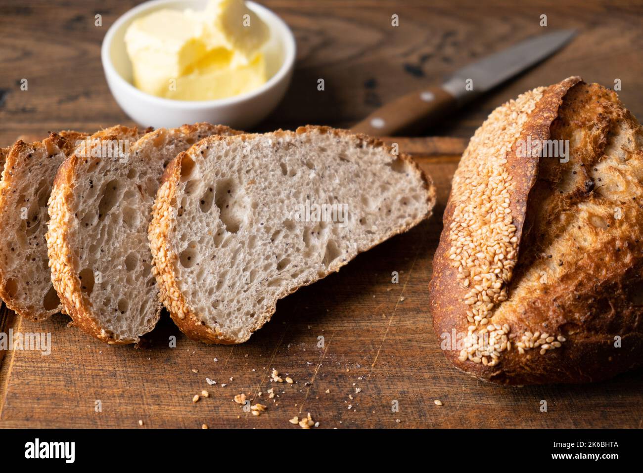Handwerkliches Brot und Butter auf Holzbrett. Gesundes Weißgesäuertes Brot Stockfoto