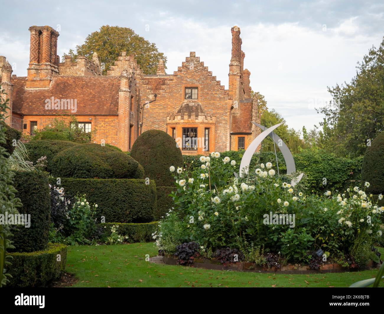 Chenies Manor Weißer Garten mit weißen Dahlien und beschnittenen Eibentopiarie im Oktober. Stockfoto