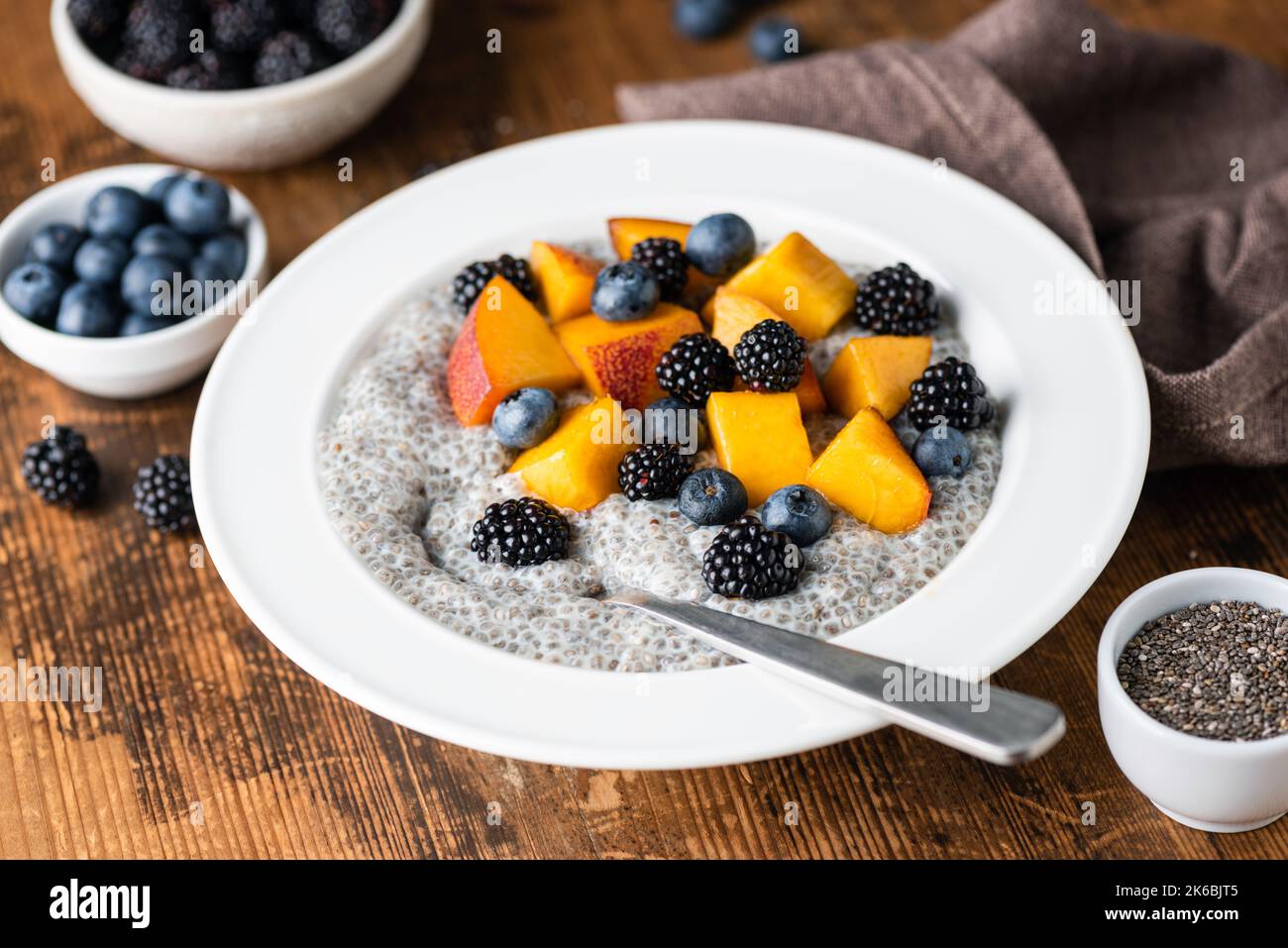 Chia Puddingschüssel mit Beeren und Früchten auf rustikalem Holztisch Hintergrund. Konzept der Diät, saubere Ernährung Stockfoto